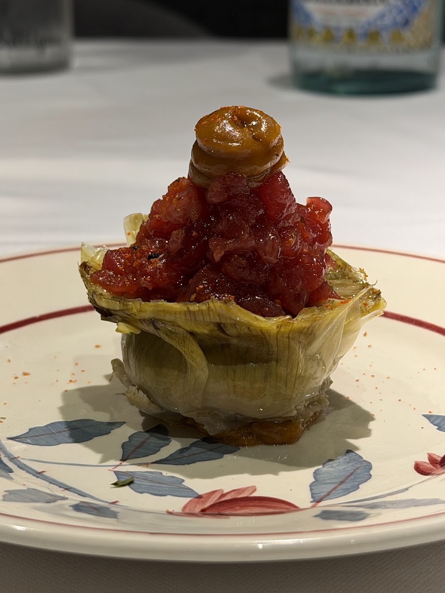 Hojaldre relleno de tártar con guarnición sobre plato blanco